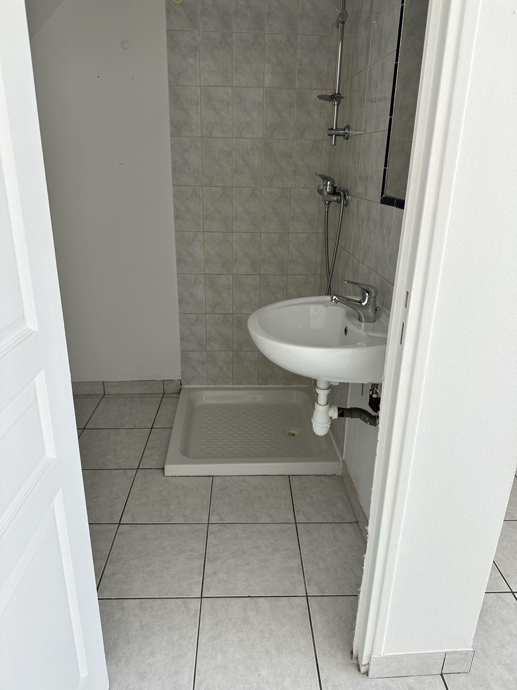 La salle d'eau remise en état : douche, lavabo et sol nettoyés et désinfectés