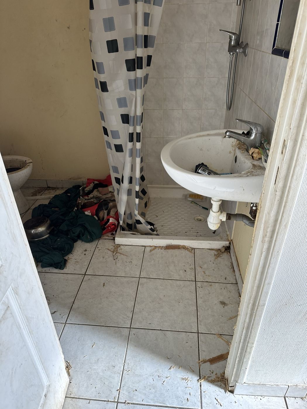 Salle d'eau encombrée et encrassée avant remise en état sanitaire