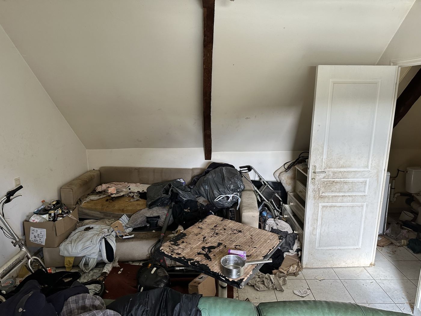 Séjour d'un logement laissé encombré de meubles et d'affaires, avant débarras et remise en état par AM-PureZone